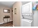 A hallway featuring a stacked washer and dryer, framed picture, and decorative metal table at 615 Midway Dr # B, Ocala, FL 34472