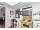 Galley kitchen featuring vintage yellow stove, white cabinets, and open shelving at 615 Midway Dr # B, Ocala, FL 34472