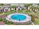 An aerial view of a community pool with sun loungers surrounded by lush landscaping and inviting blue water at 615 Midway Dr # B, Ocala, FL 34472