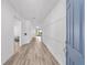Bright entryway featuring a wood floor, paneled wall, and views of the dining area and kitchen at 7908 Sw 89Th Cir, Ocala, FL 34481