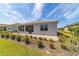 Rear exterior view of the home, featuring well-manicured landscaping and a screened-in lanai at 7908 Sw 89Th Cir, Ocala, FL 34481