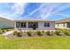Back exterior showcasing a landscaped yard and a screened-in patio at 7908 Sw 89Th Cir, Ocala, FL 34481