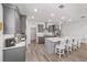 Modern gray kitchen with stainless steel appliances, a large island with seating, and a seamless flow to other areas at 7908 Sw 89Th Cir, Ocala, FL 34481