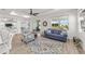 Bright living room with a blue sofa, view into the kitchen, and sliding glass doors to outdoor living at 7908 Sw 89Th Cir, Ocala, FL 34481