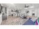 Open floor plan with a living room featuring a blue sofa and view into the modern gray kitchen and dining area at 7908 Sw 89Th Cir, Ocala, FL 34481