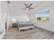 Well-lit primary bedroom with tray ceiling, wood-look floors, and white trim at 7908 Sw 89Th Cir, Ocala, FL 34481
