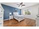 Bedroom with sleek ceiling fan, blue accent wall, and wood look flooring at 8342 Sw 82Nd Loop, Ocala, FL 34481