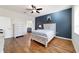 Bedroom featuring hardwood floors, a ceiling fan, and decoratively painted accent wall at 8342 Sw 82Nd Loop, Ocala, FL 34481