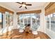 Bright sun room with large windows, wood floors, and comfortable seating area at 8342 Sw 82Nd Loop, Ocala, FL 34481