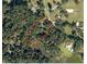 An aerial view of the property showcasing its secluded location surrounded by lush trees and the neighboring horse training facility at 8380 Se 7Th Avenue Rd, Ocala, FL 34480