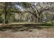 Expansive backyard featuring mature trees, a detached garage, and a charming gazebo at 8380 Se 7Th Avenue Rd, Ocala, FL 34480