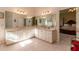 Bright bathroom featuring tiled floors, a dual vanity, and a large mirror at 8380 Se 7Th Avenue Rd, Ocala, FL 34480