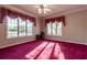 Bright bedroom with large windows, red carpet and decorative window treatments at 8380 Se 7Th Avenue Rd, Ocala, FL 34480