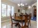 Cozy dining area features round wood table, decorative wood chairs, and natural light through windows at 8380 Se 7Th Avenue Rd, Ocala, FL 34480