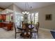 Dining room has wood table with decorative chairs, large windows and adjacent kitchen area at 8380 Se 7Th Avenue Rd, Ocala, FL 34480