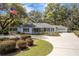 Charming single-story home with a manicured lawn, circular driveway, and an inviting front porch perfect for relaxation at 8380 Se 7Th Avenue Rd, Ocala, FL 34480