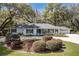 Charming single-story home with a manicured front yard, mature trees, and classic American Flag at 8380 Se 7Th Avenue Rd, Ocala, FL 34480