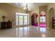 Spacious foyer with marble floors, arched doorways, a chandelier, and double doors leading to an outdoor patio at 8380 Se 7Th Avenue Rd, Ocala, FL 34480