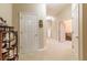Hallway featuring multiple doorways, neutral-toned walls, and a classic display cabinet with decorative items at 8380 Se 7Th Avenue Rd, Ocala, FL 34480