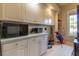 Functional laundry room with white cabinets, ample counter space and golf accessories at 8380 Se 7Th Avenue Rd, Ocala, FL 34480