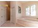 Tranquil bathroom featuring a jacuzzi tub, tiled floors, and a glass-enclosed shower at 8380 Se 7Th Avenue Rd, Ocala, FL 34480