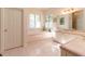 Serene bathroom featuring a jacuzzi tub, tiled floors, and a double vanity with a marble countertop at 8380 Se 7Th Avenue Rd, Ocala, FL 34480