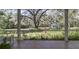Charming screened-in porch offering scenic views of the tranquil yard and a distant gazebo at 8380 Se 7Th Avenue Rd, Ocala, FL 34480