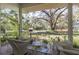 Picturesque screened-in porch featuring comfortable wicker furniture and views of the lush greenery at 8380 Se 7Th Avenue Rd, Ocala, FL 34480