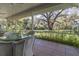 Covered screened-in patio with outdoor seating and views of the beautifully landscaped yard at 8380 Se 7Th Avenue Rd, Ocala, FL 34480