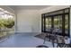 Covered porch with black metal chairs, porch swing and black framed double doors leading inside at 8380 Se 7Th Avenue Rd, Ocala, FL 34480