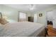 Cozy bedroom with a dresser, ceiling fan, hardwood floors, and bathroom and closet access at 8917 Sw 101St Ln, Ocala, FL 34481