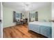 Bedroom featuring wood floors, a ceiling fan, and a work area with desk, chair and safe at 8917 Sw 101St Ln, Ocala, FL 34481
