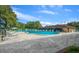 Large community pool with lounge chairs and tables with a fenced-in area surrounded by lush trees at 8917 Sw 101St Ln, Ocala, FL 34481