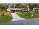 Welcoming home with a long driveway, covered carport, and a lush front lawn, embodying classic charm at 8917 Sw 101St Ln, Ocala, FL 34481