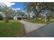 Inviting single-story home featuring a long driveway, covered carport, and a well-maintained front lawn with an American flag at 8917 Sw 101St Ln, Ocala, FL 34481