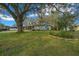 Single story home with a manicured lawn and trees casting shadows on a sunny day, offering suburban charm at 8917 Sw 101St Ln, Ocala, FL 34481
