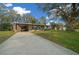 Charming single-story home with a long driveway, covered carport, and a spacious front yard with mature trees at 8917 Sw 101St Ln, Ocala, FL 34481
