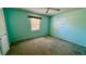 A cozy bedroom with soothing teal walls, carpet, and a large window dressed with a floral valance at 10370 Sw 110Th St, Dunnellon, FL 34432