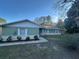 Charming single-story home featuring a well-maintained lawn and a classic facade with white-framed windows at 10370 Sw 110Th St, Dunnellon, FL 34432