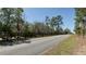 Street view showing a long driveway entrance to the property with surrounding trees at 10370 Sw 110Th St, Dunnellon, FL 34432