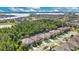 Expansive aerial view of a community with a lake in the distance, surrounded by lush greenery at 1073 Vinsetta Cir, Winter Garden, FL 34787
