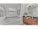 Bright bathroom featuring a soaking tub and a vanity with dark cabinets at 1073 Vinsetta Cir, Winter Garden, FL 34787