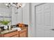 Bathroom with a granite countertop, wood cabinets, and a decorative mirror and lighting fixture at 1073 Vinsetta Cir, Winter Garden, FL 34787