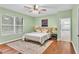 Calm bedroom with a large window providing natural light, hardwood floors, and an open doorway to a bathroom at 1073 Vinsetta Cir, Winter Garden, FL 34787