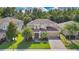 Attractive two-story home featuring a brick driveway, lush green lawn, and mature palm trees at 1073 Vinsetta Cir, Winter Garden, FL 34787