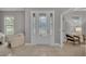 Bright foyer with decorative glass front door and sidelights, neutral decor, and tile flooring at 1073 Vinsetta Cir, Winter Garden, FL 34787