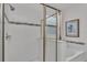 A walk-in shower with a glass door and white tile and a tiled accent border, next to a soaking tub at 1073 Vinsetta Cir, Winter Garden, FL 34787