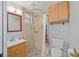 Bathroom featuring tiled walk-in shower, vanity with mirror, and a toilet with functional cabinetry at 11 Se 31St St, Ocala, FL 34471