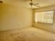 Spacious bedroom with ceiling fan, carpet flooring, and natural light from window at 11255 Sw 76Th Ter, Ocala, FL 34476
