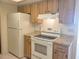 Bright kitchen featuring white appliances, wood cabinets, and stone countertops at 11255 Sw 76Th Ter, Ocala, FL 34476